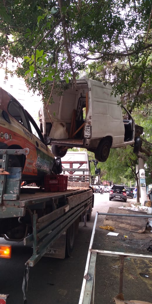 Veículo na cor branca sendo recolhido por um guincho